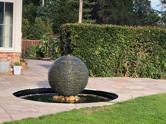 1m (Large) Rustic Watersphere™ on a pond. Column has been surrounded by stones already existing in the garden.